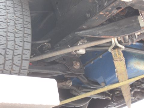 1968 Shelby GT500 - Close-up of vehicle undercarriage with suspension parts and a tire visible.