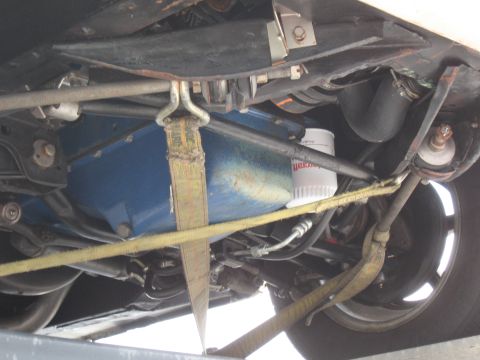 1968 Shelby GT500 - The underside of a vehicle is shown, secured with yellow tie-down straps.