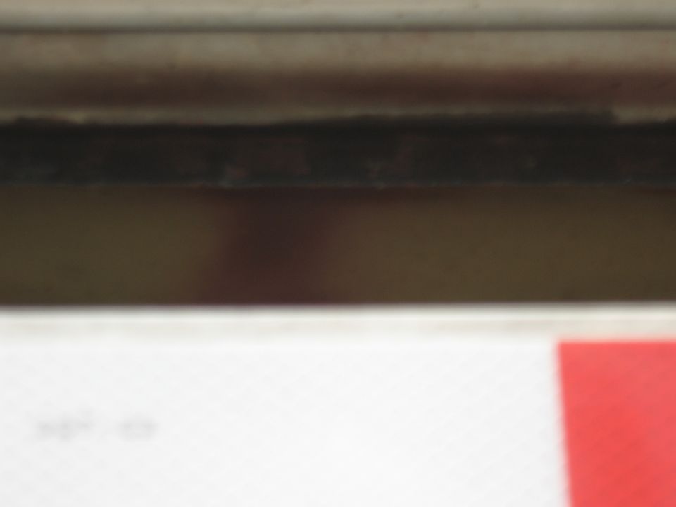 Close-up of dark interior trim with a red object in the corner