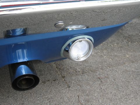 1968 Shelby GT500 - A close-up shot of a car's rear bumper shows a round light and exhaust pipe.