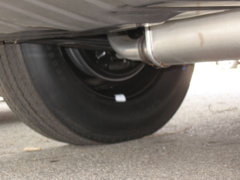 1968 Shelby GT500 - Underside view of a vehicle's exhaust system and tire.