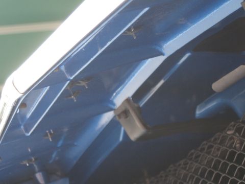 1968 Shelby GT500 - Close-up view of the underside of a blue car hood, showing structural details and fasteners.
