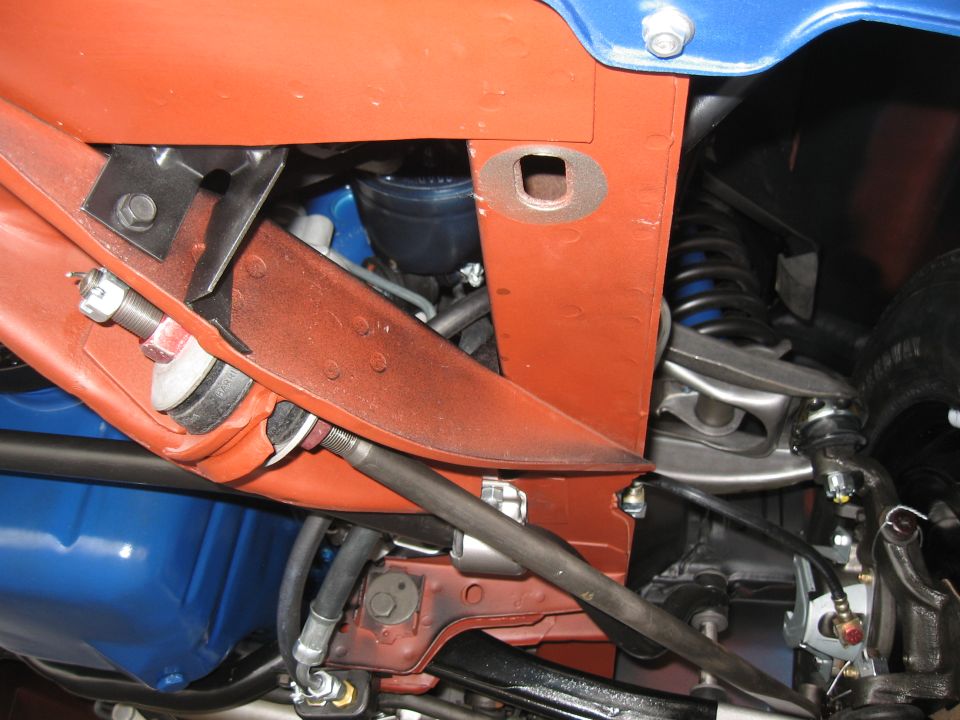 Underside of a blue car with orange painted chassis components, showing suspension and brake lines