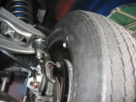 1968 Shelby GT500 - A close-up view of a vehicle's front suspension system and tire, highlighting the brake components.