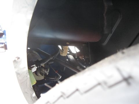 1968 Shelby GT500 - A close-up view of a vehicle's tire and undercarriage reveals complex mechanical and electrical components.