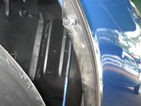 1968 Shelby GT500 - Close-up view of a blue car's wheel well, showing the tire and part of the fender trim. The Supermotors.net logo is visible in the lower ri…