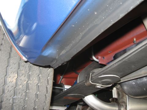1968 Shelby GT500 - Close-up view of the rear suspension and exhaust system of a blue vehicle, with visible text from Supermotors.net.