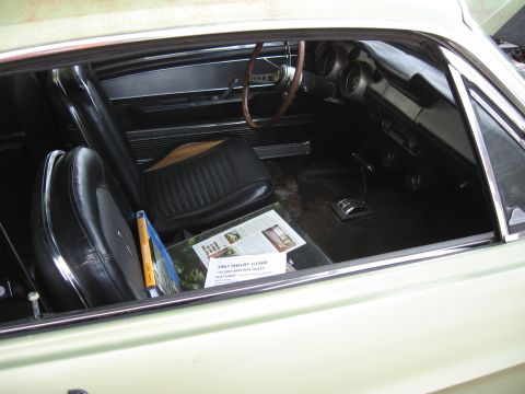 1968 Shelby GT500 - The interior of a classic car, black seats and a magazine on the passenger seat.