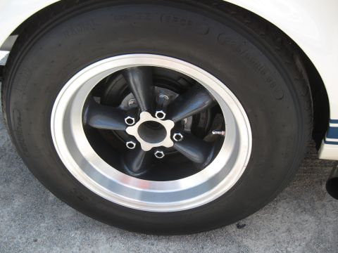 1968 Shelby GT500 - A close-up view of a wheel and tire assembly on a white vehicle with racing stripes.