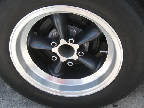 1968 Shelby GT500 - A five-spoke wheel with a polished lip and black spokes is shown in a close-up view.