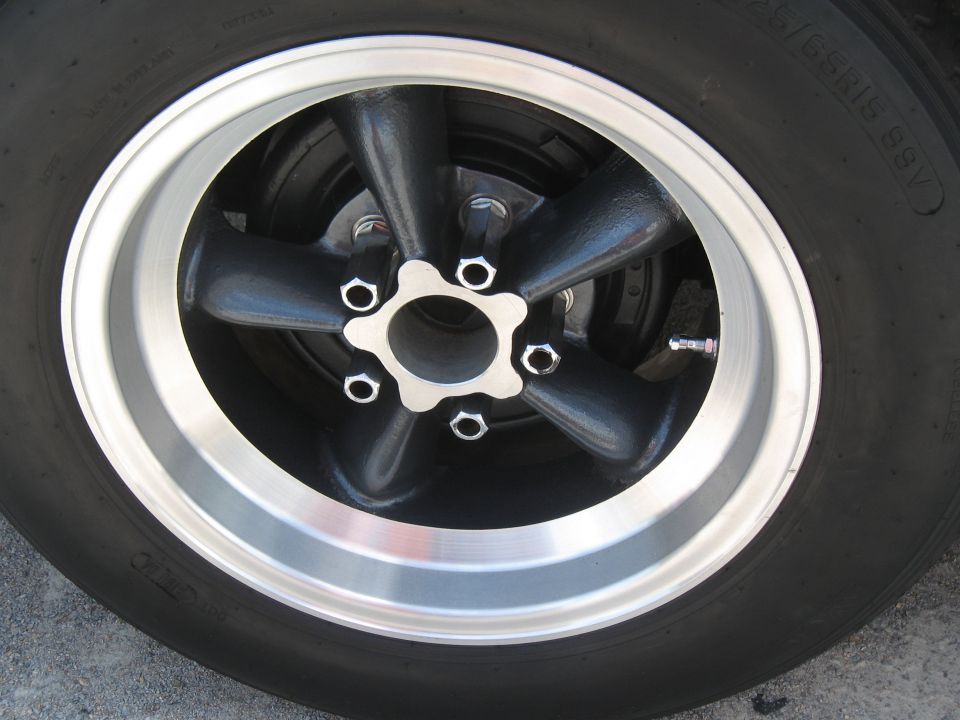 Close-up of a five-spoke wheel with a polished lip and black spokes
