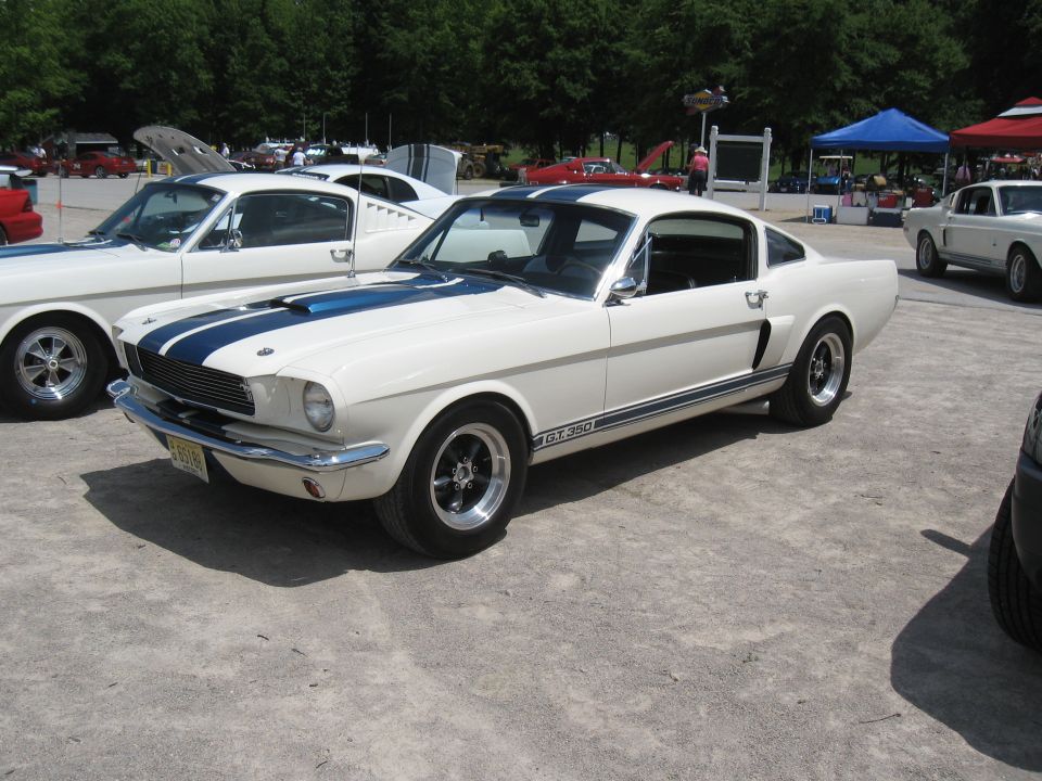 White 1965 Shelby GT350 with blue racing stripes and GT350 badging on the side