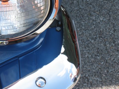 1968 Shelby GT500 - Close-up view of the front corner of a blue vehicle, highlighting the chrome bumper and headlight assembly.