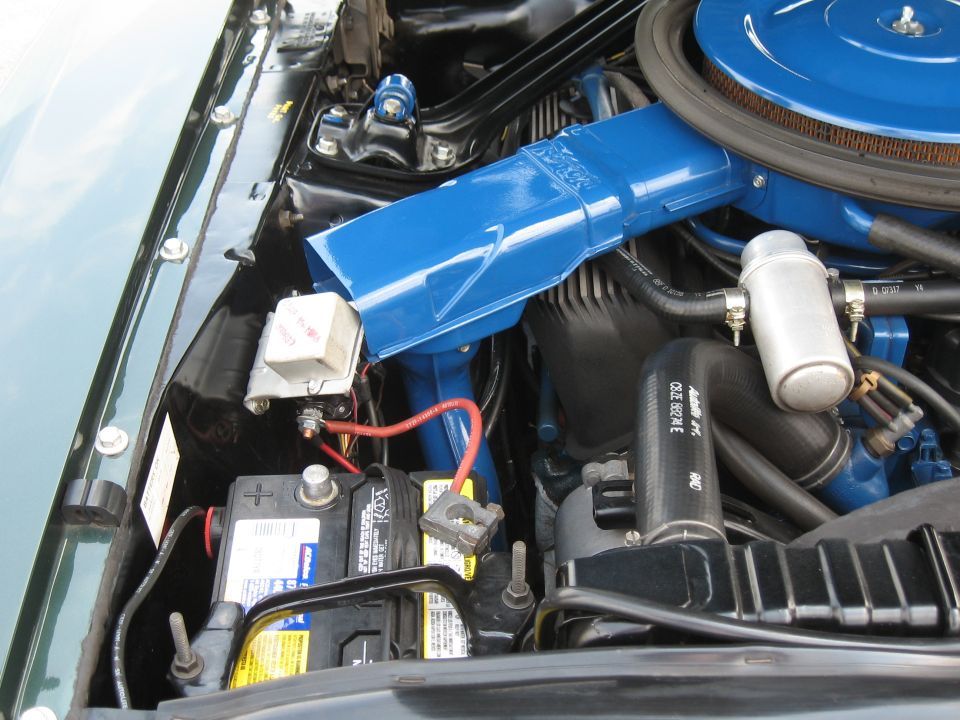 Engine bay with blue air cleaner housing and battery