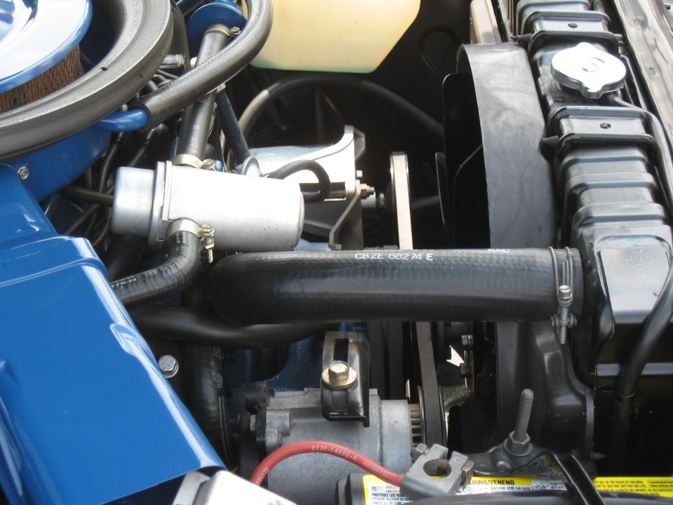 Engine bay detail showing radiator, fan, hoses, and alternator. Text on hose reads CBZE 60274 E