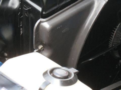 1968 Shelby GT500 - Close-up of engine bay components, including a fluid reservoir and fender liner with Ford branding.