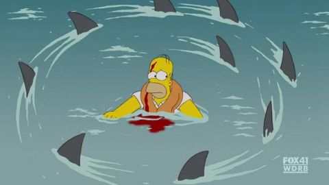 1990 Ford Bronco - Homer Simpson is in the water with blood and shark fins circling him.