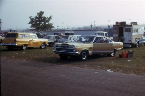 1967 Ford Fairlane - Two drag cars and a station wagon are parked on the grass at a race track, with spectators in the background.
