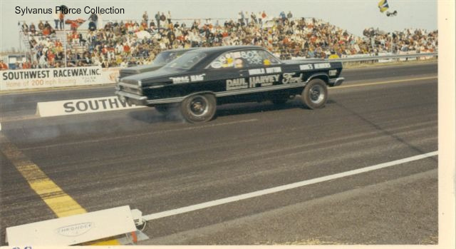 Dark Ford drag car launching at Southwest Raceway with Paul Harvey Ford lettering