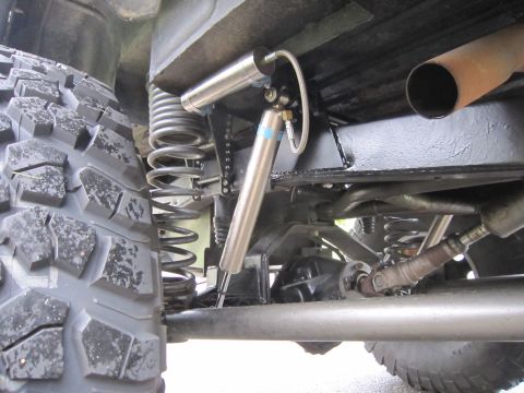 1974 Ford Bronco - Rear suspension detail showing a tire, coil spring, and Bilstein shock absorber mounted to the frame.