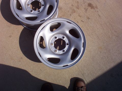 1988 Ford Bronco - Two silver steel wheels are shown resting on a concrete surface.