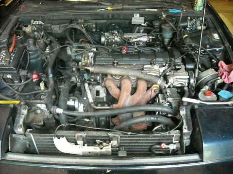 1979 Ford F-150 - The engine bay of a car is shown with various mechanical parts and wiring.