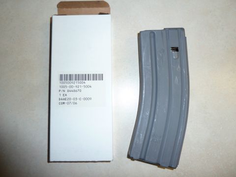 1992 Ford Mustang - A gray firearm magazine is shown next to its original packaging, which includes detailed part information.