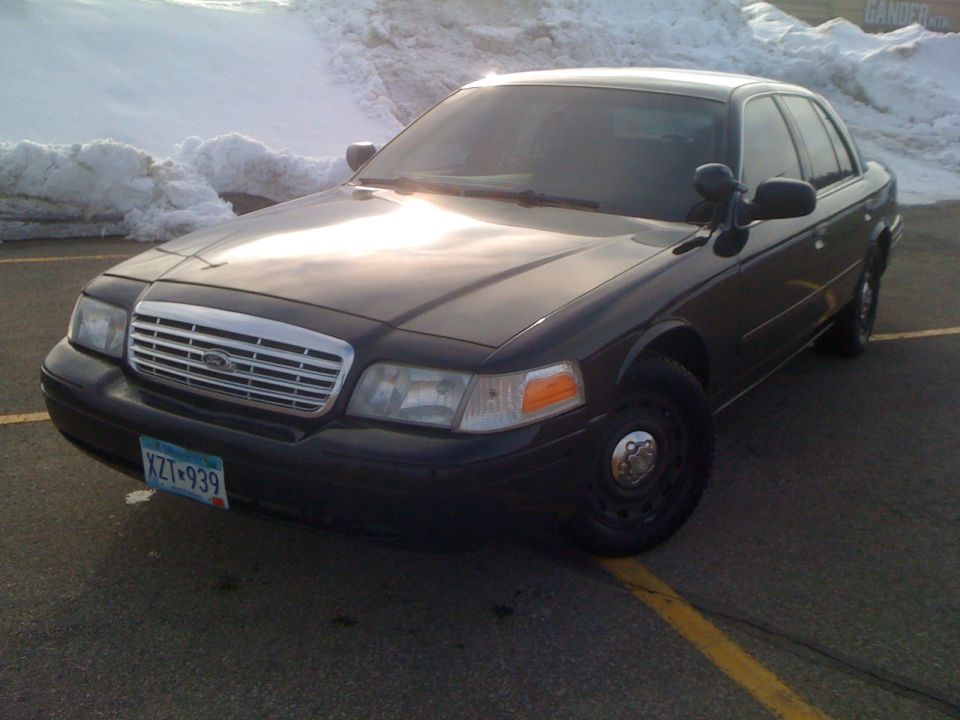 Black Ford Crown Victoria, front 3/4 view, showing a chrome grille and license plate XZT-939