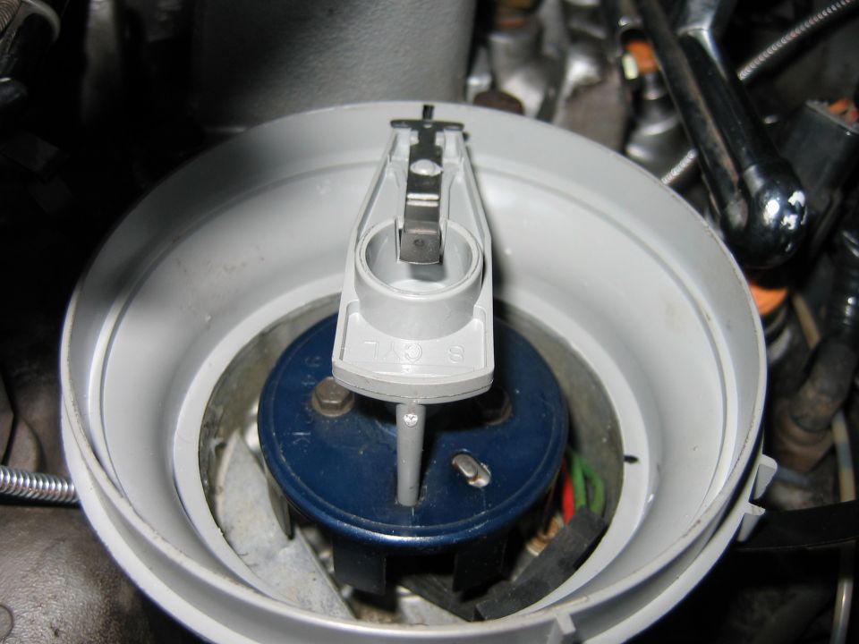 Close-up of a Ford distributor cap and rotor assembly. Numbers 1, 3, 5, 7, 9 are visible on the cap