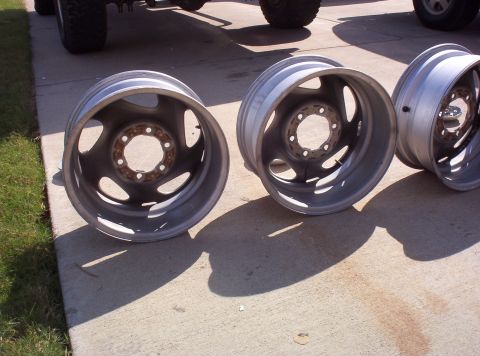 1988 Ford Bronco - Two aluminum wheels are shown, likely for a truck or SUV, resting on a concrete surface.