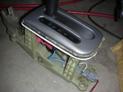 1998 Ford Crown Victoria - Close-up of an automatic shifter assembly showing the PRND21 gate plate, internal springs and colored wiring.