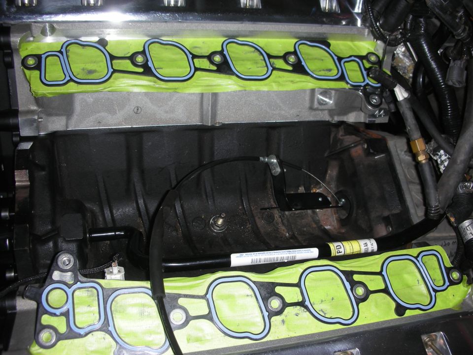Engine intake manifold gaskets with green tape and blue sealant