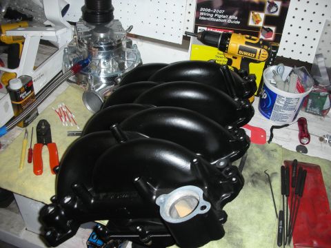 1992 Ford Crown Victoria - Engine parts including an intake manifold and supercharger are laid out on a workbench with tools.