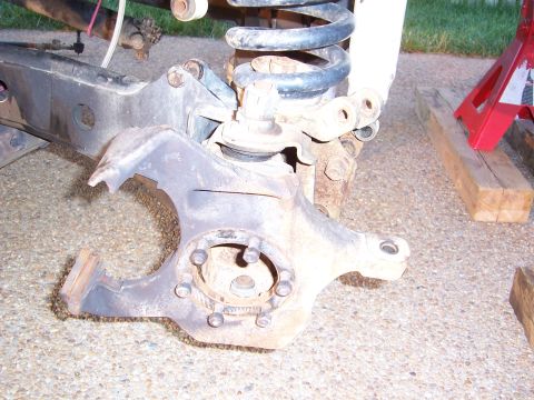 1992 Ford Bronco - Close-up of a front suspension knuckle, likely from an SUV or truck, showing its components and mounting points.