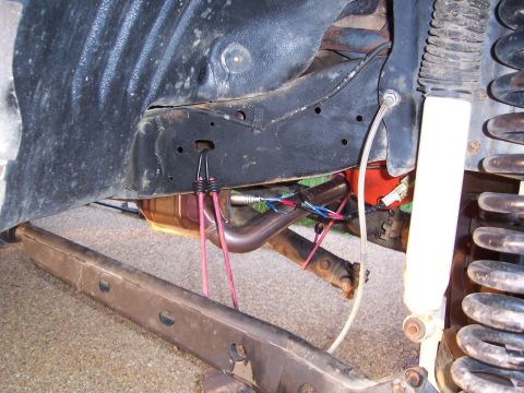 1992 Ford Bronco - Close-up of vehicle undercarriage, focusing on exhaust and suspension parts.