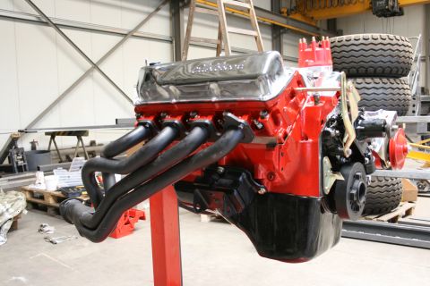 1973 Ford Ranchero - A rebuilt V8 engine sits on a stand in a workshop, ready for installation.