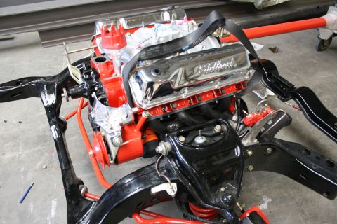1973 Ford Ranchero - Engine and front suspension assembly is being worked on in a garage setting.