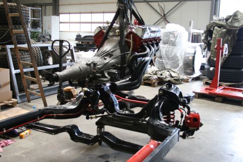 1973 Ford Ranchero - A workshop scene shows a vehicle's frame and a large engine assembly suspended by a hoist.