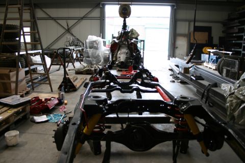 1973 Ford Ranchero - A vehicle chassis and engine are disassembled in a workshop, awaiting reassembly.