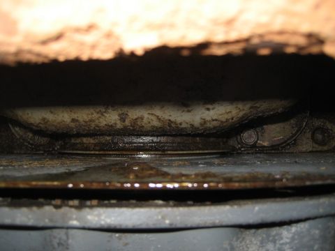 1995 Ford Bronco - Close-up view of the underside of a vehicle, showing signs of wear and leakage.