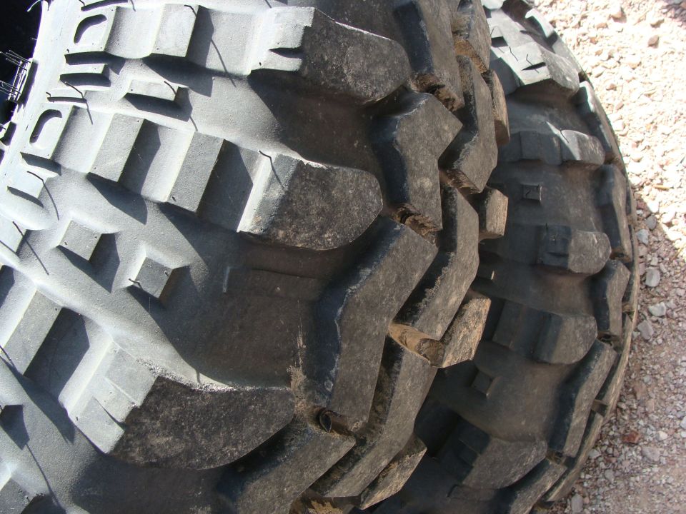 Close-up of two large, aggressive off-road tires with deep treads