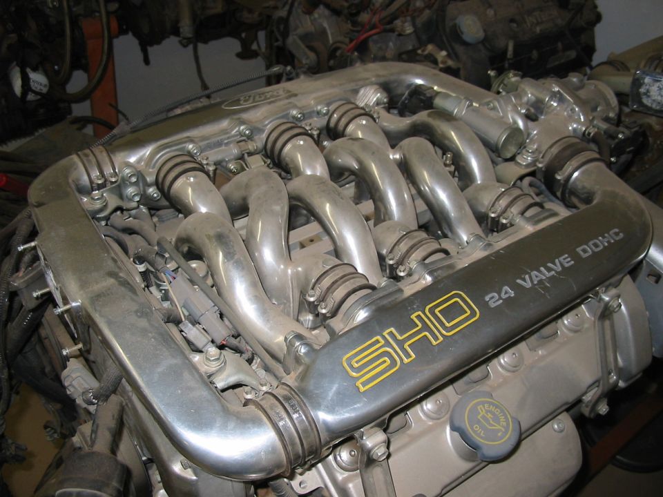 Ford SHO 24-valve DOHC V6 with polished tubular intake manifold, viewed from above on a bench
