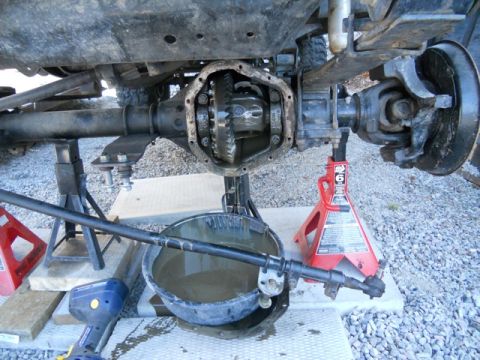 1986 Ford F-150 - Vehicle differential is open and exposed for service, supported by jack stands with a drain pan below.