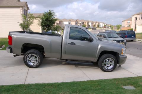2007 Chevrolet Silverado 1500 - Side view of a silver 2007 Chevrolet Silverado 1500 pickup truck parked on a suburban driveway.