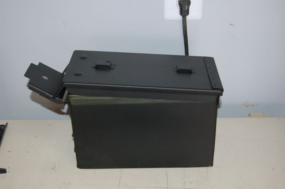 Dark green metal toolbox with hinged lid open, showing interior