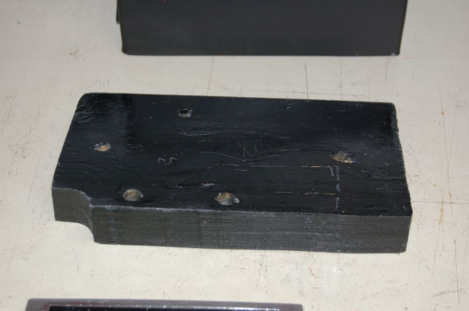 Black toolbox mounting bracket with four bolt holes