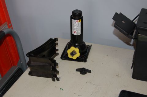 2007 Chevrolet Silverado 1500 - Car jack and associated parts laid out on a table, with a ladder visible on the left.
