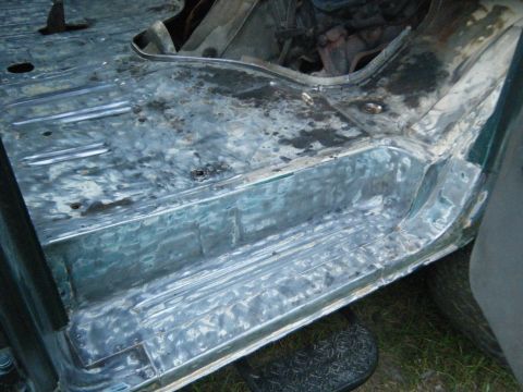 1981 Ford E350 - The interior floor of a vehicle shows signs of repair and rust.