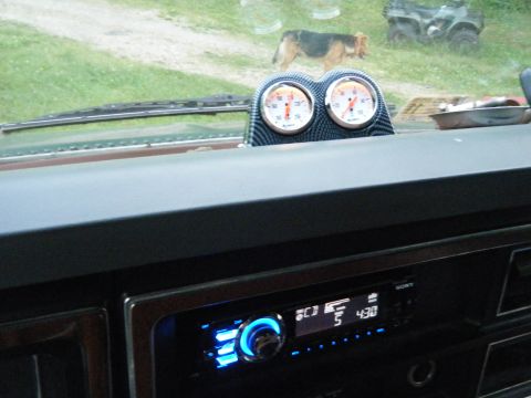1981 Ford E350 - Interior view of a vehicle's dashboard, gauges and a stereo, with a dog and ATV seen outside.