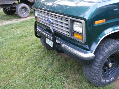 1981 Ford E350 - A green van with a black bull bar is parked on grass next to another vehicle.